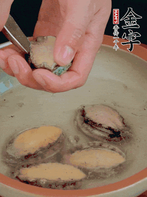 鮑魚加鹽、清水浸泡，用勺子挖出鮑魚肉。