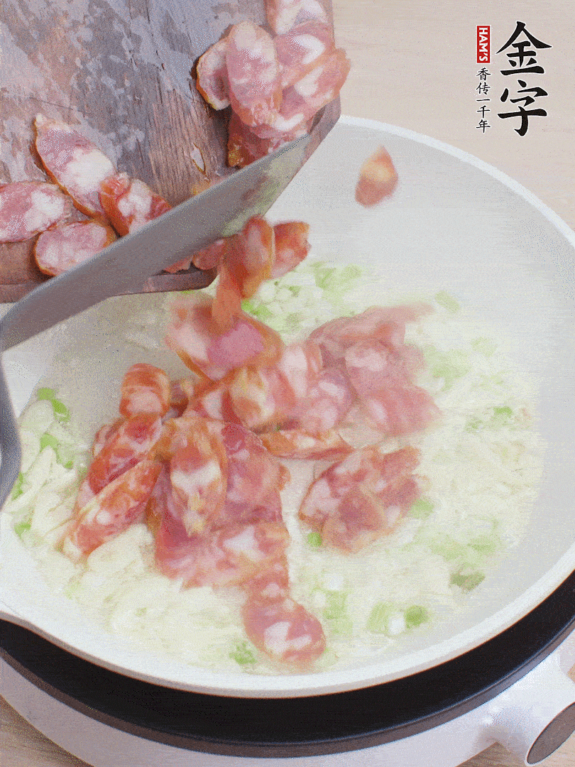 油5成熱，蒜末、蔥白爆香，下香腸炒出香味。