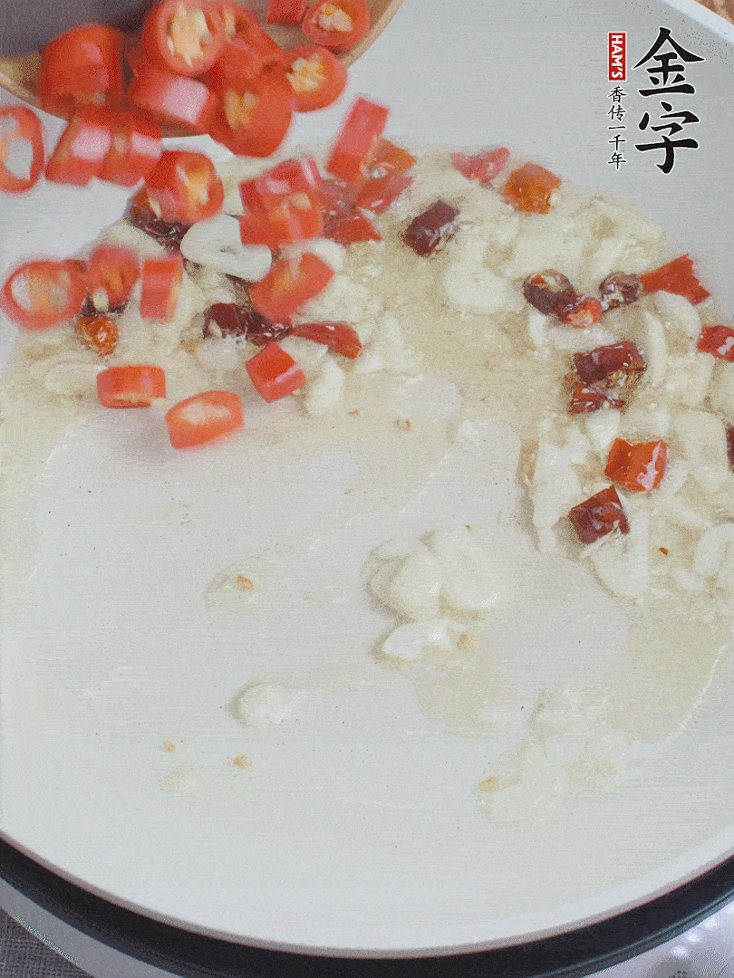 油6成熱，下蒜末、干紅辣椒煸炒，出香味后再放美人椒、香腸。