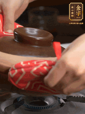 中火調成小火，鋪上香腸蓋蓋燜5分鐘。不斷轉動瓦煲，讓側壁的飯形成飯焦