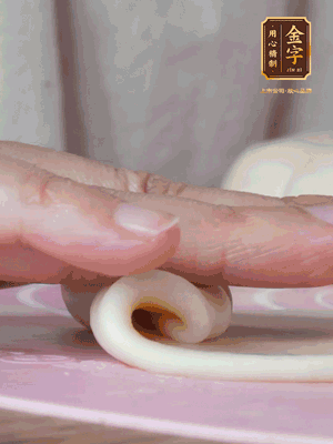 做面劑 油皮按扁，中間包入一個油酥，邊緣收緊捏死。包好的面劑按扁，用搟面杖搟壓成橢圓形。從底部向上卷成筒狀，用保鮮膜蓋好松弛15分鐘，再把筒狀縱向搟壓成長條狀。再卷一次，松弛20分鐘